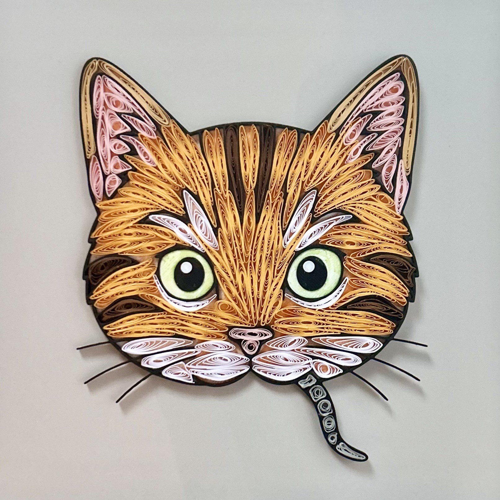 Cat with a rat's tail hanging from the corner of its mouth; made with paper, PLA, and mixed media.
