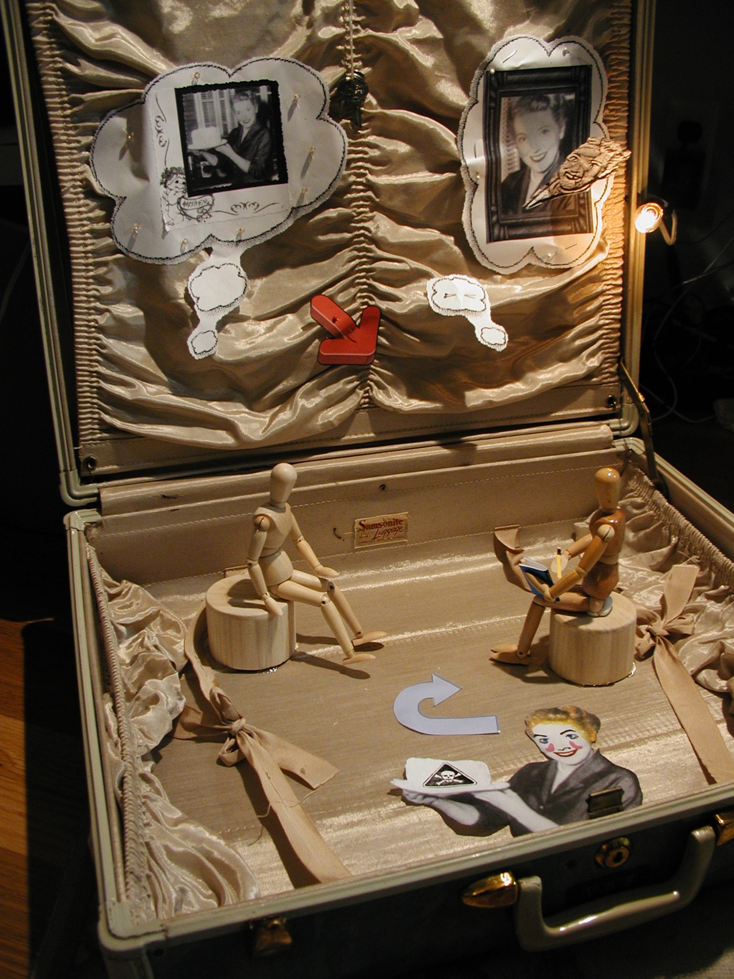 Assemblage piece with vintage 1950's suitcase, wood figures and mixed paper