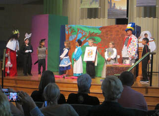 Children in costumes performing on stage.