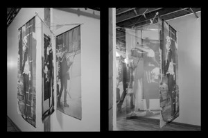 A black and white photograph of photographs on silk in a gallery.