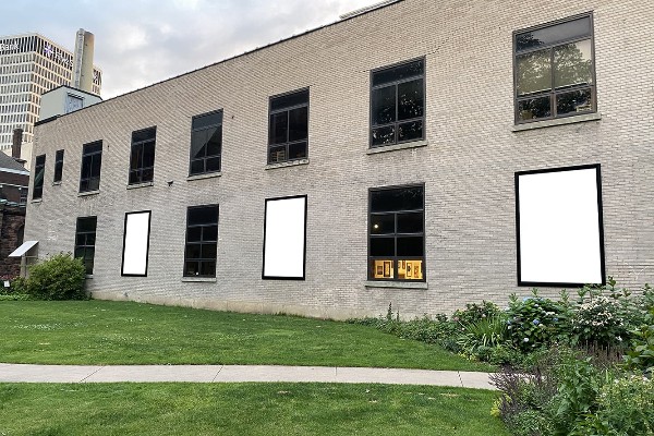 Photo of side of building with 3 blank canvases set up for Public Art installation.